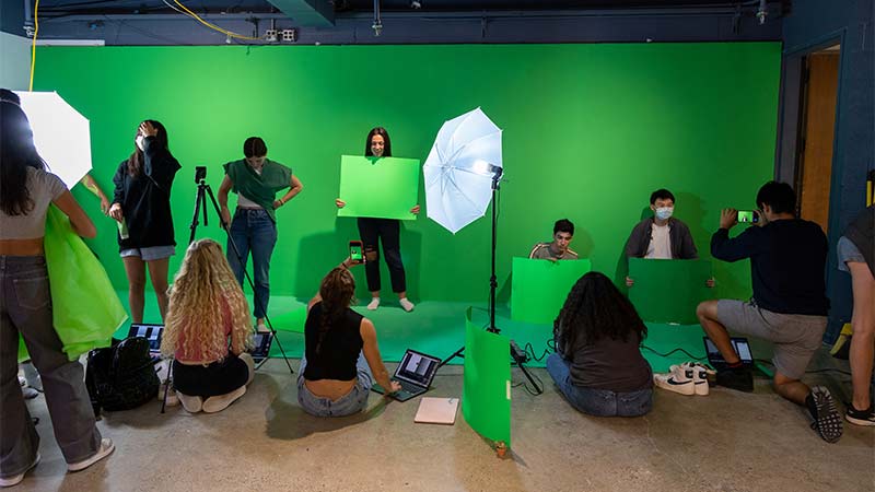 Students work with a green screen to create visual experiences.